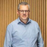 Headshot of man in blue shirt